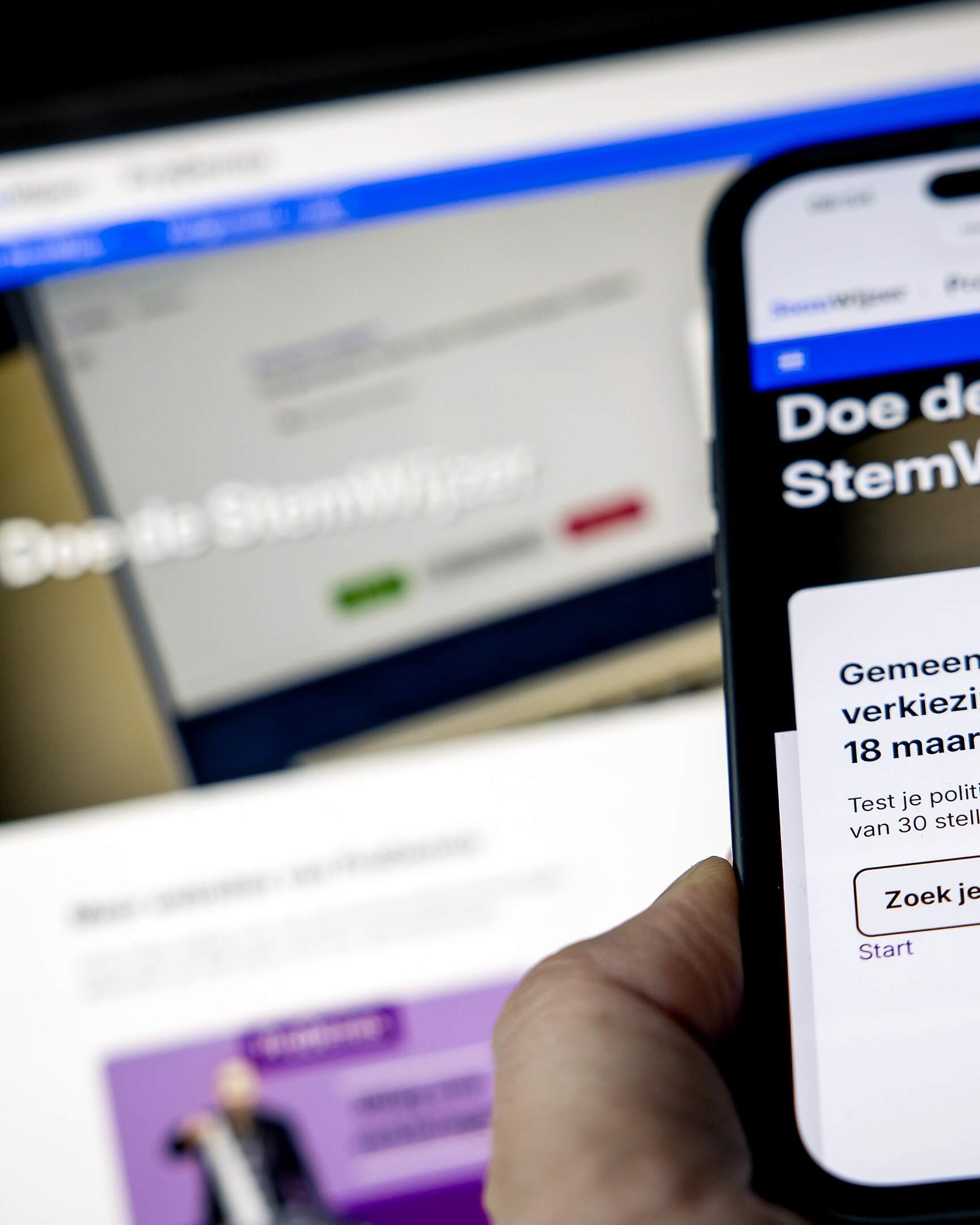 ILLUSTRATIEF - Een laptop en een mobiele telefoon met de website van StemWijzer voor de Gemeenteraadsverkiezingen 2026. KOEN VAN WEEL / ANP
